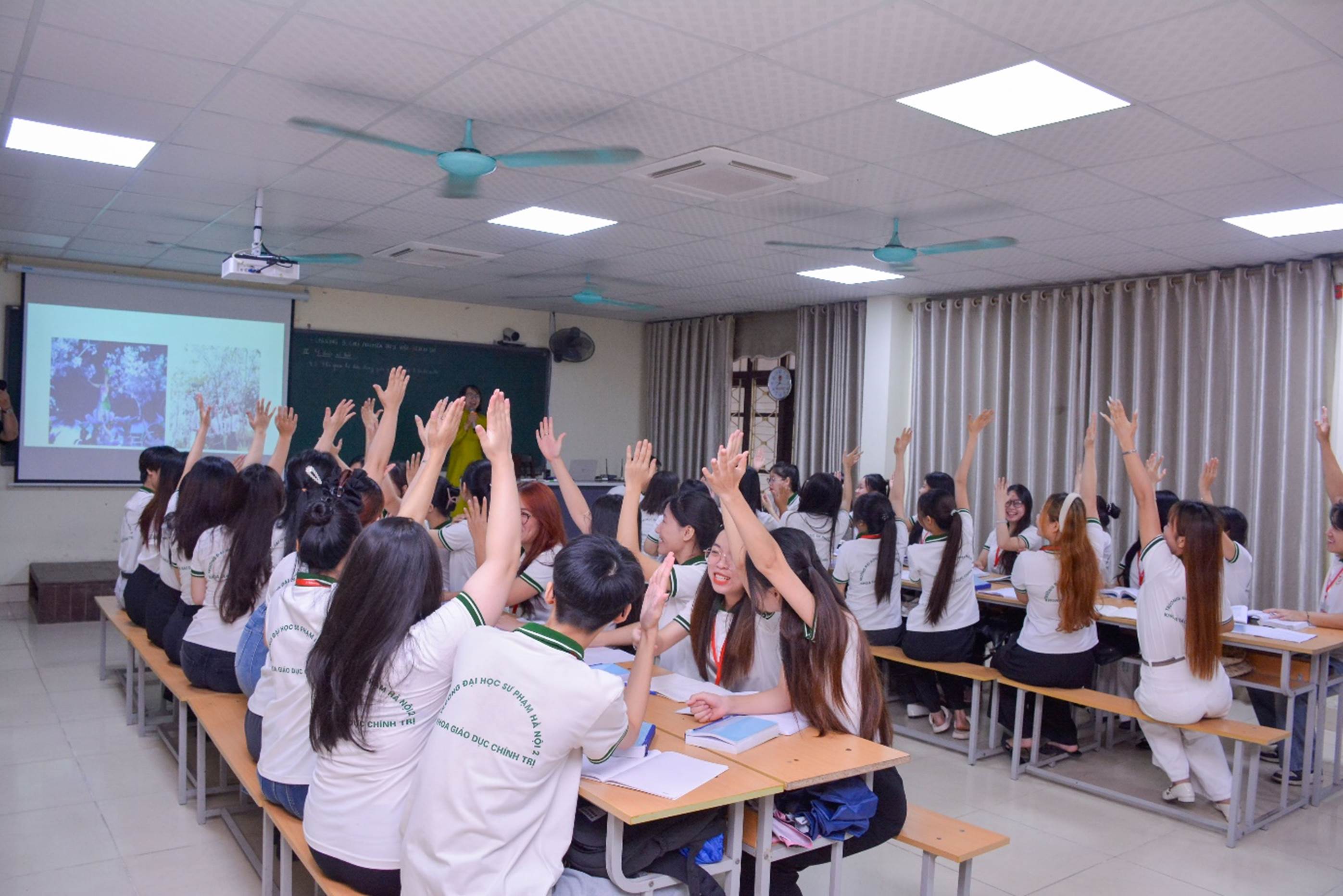 A group of students raising their hands in a classroom

AI-generated content may be incorrect.