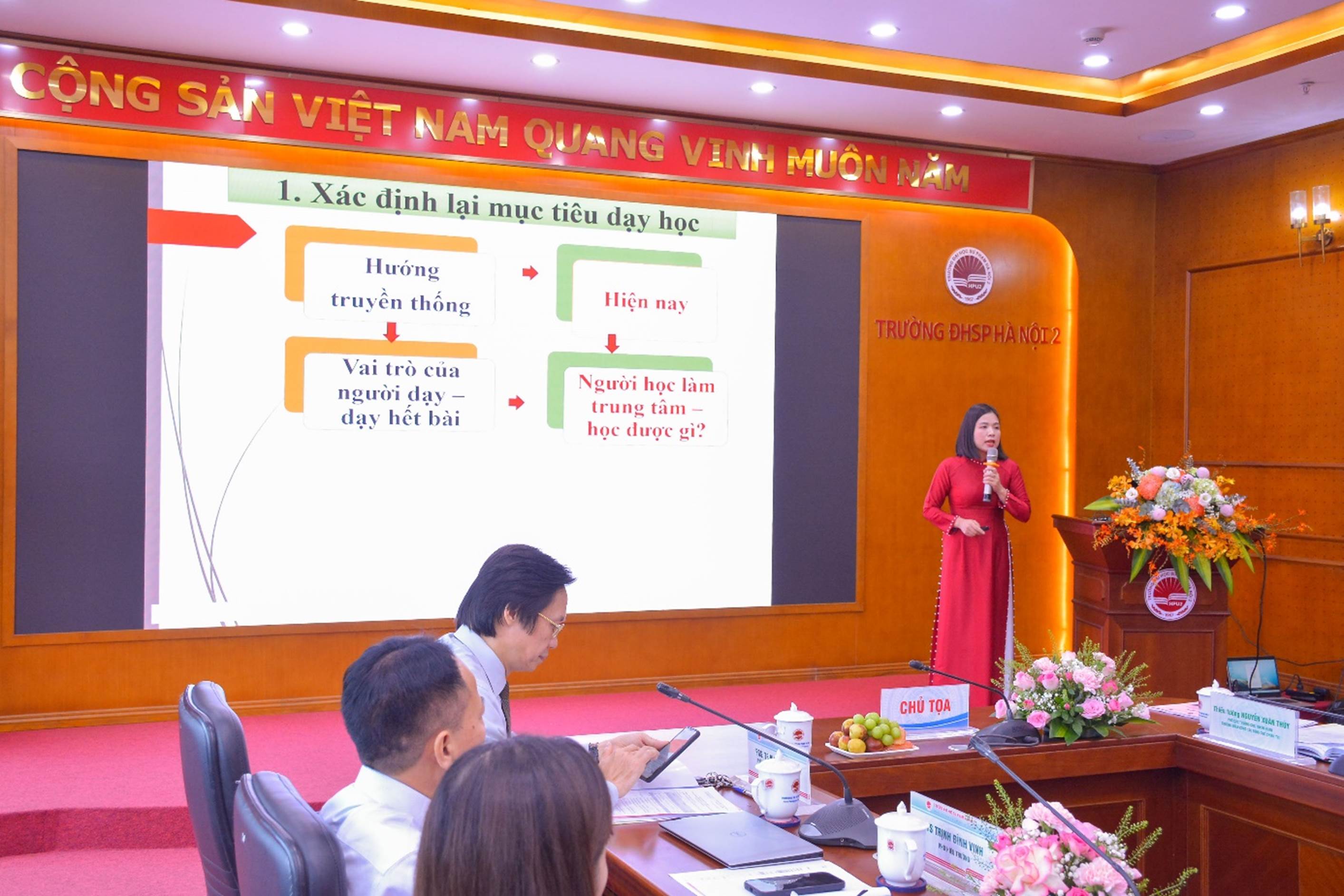 A person in a red dress standing in front of a large screen

AI-generated content may be incorrect.