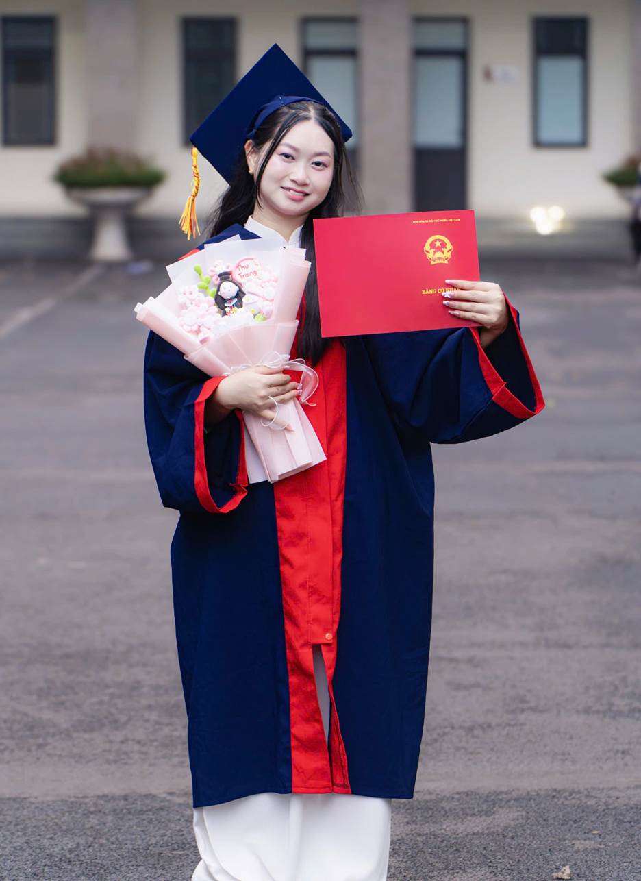 A person in a graduation gown holding a diploma and flowers

AI-generated content may be incorrect.